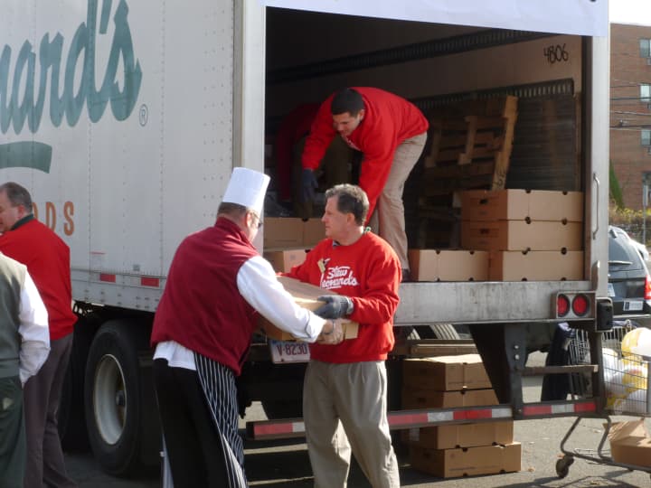 Andrew Colton, president of the Norwalk Stew Leonard&#x27;s, hands a box of turkeys to Michael Luboff, head chef at the Norwalk Stew Leonard&#x27;s, during the company&#x27;s annual turkey donation initiative Thursday.