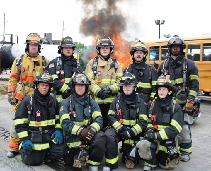 New career firefighters in their gear. Kneeling from right to left: Heriberto Virella, William Simons, Thomas Leonard and Cea Fong. Back Row: Christopher Duffelmeyer, Christopher Rimm, Michael Mackenzie, John Giordano Jr. and , Hassan Washington.