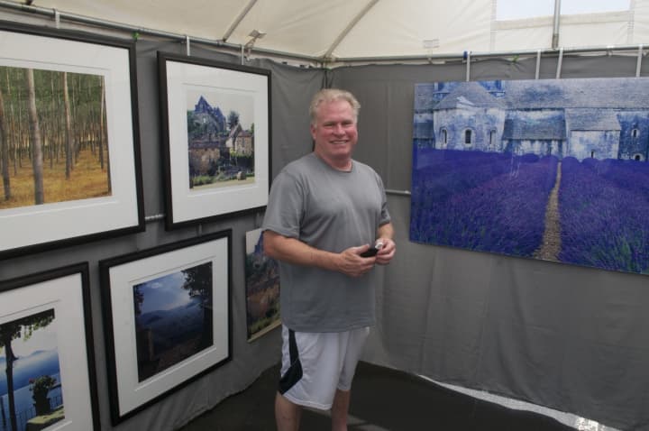 Westport photographer Ron Lake stands with some of his work at the fine art sale.
