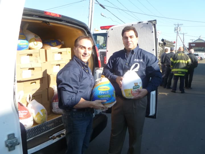 Rich Cunningham (right), owner of Ed&#x27;s Garage Doors, loads turkeys donated by local residents during his Norwalk food drive into a delivery truck.