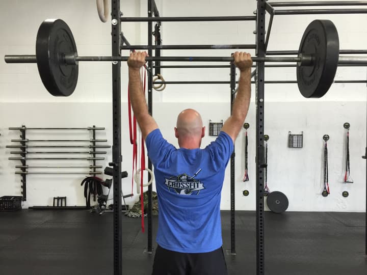 CrossFit General Manager Tim Deenihan demonstrates a lift at the gym Tuesday.