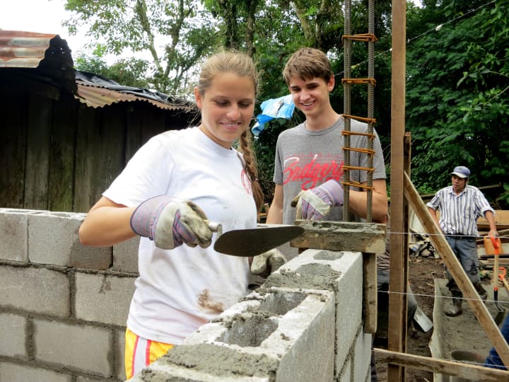Third-time trip participant and recent Mamaroneck High School graduate Freya Cantwell and second-time trip participant and rising Mamaroneck High School senior Axel Steinmetz build the walls of the house.