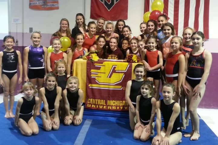 Caroline Fitzpatrick of New Canaan is flanked by her teammates at Stamford&#x27;s Arena Gymnastics as she officially commits to Central Michigan.