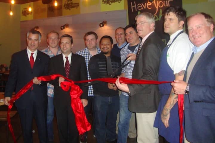 The owners of Bodega Taco Bar and members of the Darien Chamber of Commerce celebrate the opening of the new restaurant with a ribbon cutting.