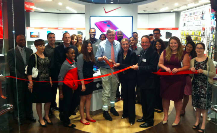 Mayor David Martin, center, prepares to cut the ribbon at the expanded Verizon Wireless store at Stamford Town Center.