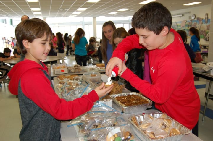 Brent Perlman (left) and Alex Shapiro, students at Armonk&#x27;s H.C. Crittenden school, work during the bake sale.