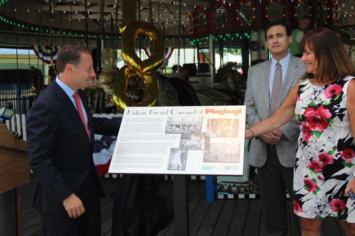 Westchester County Executive Rob Astorino, left, unveils a plaque Thursday celebrating the 100th anniversary of Playland&#x27;s Grand Carousel. Joining him is Peter Tartaglia, deputy commissioner of parks, and Kathleen O&#x27;Connor, parks commissioner. 