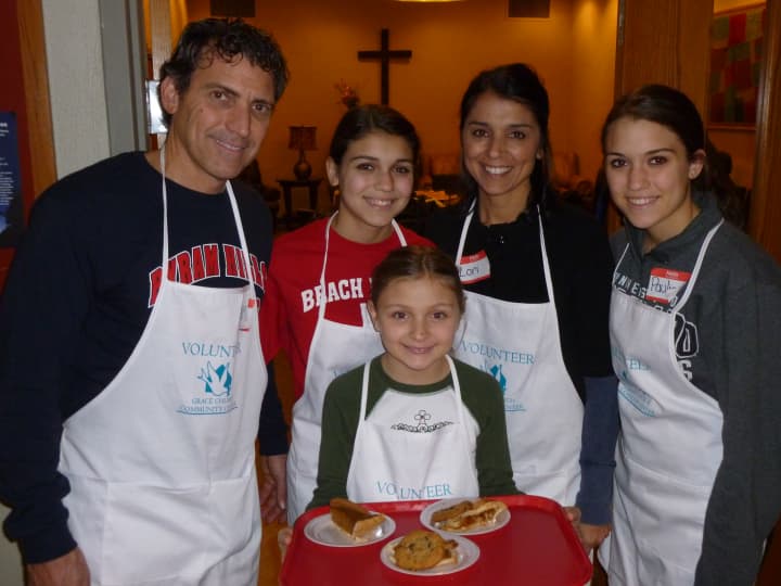 Sisters Gina (front), Emma (second from left) and Paulina (far right) help their parents serve Thanksgiving meals to the hungry Thursday in White Plains.