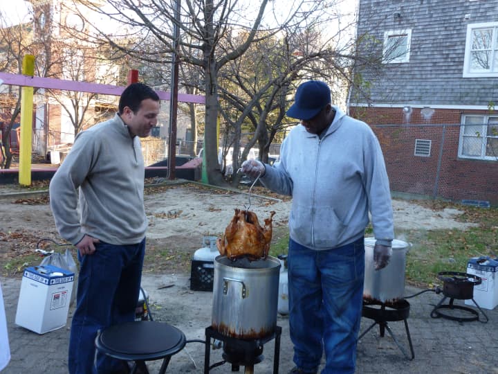 Common Councilman Warren Peña, left, and Ernie Dumas check out one of the fried turkeys for the Thanksgiving Day dinner Thursday at the South Norwalk Community Center. 