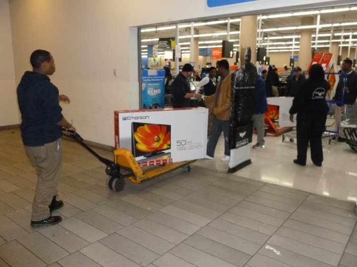 Wal-Mart customers cart out their new big-screen televisions Friday morning.