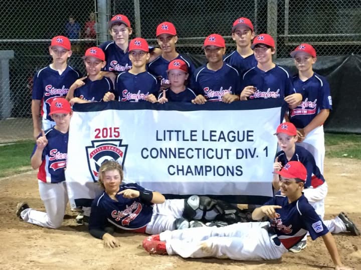 Stamford North Little League players celebrate with the Division 1 banner after beating Fairfield American on Sunday night. 