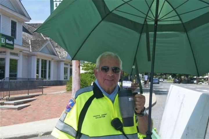 A Westport cop beats the heat with an umbrella and a cold beverage. 