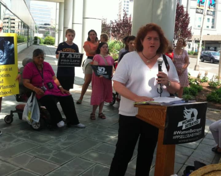 Sharon Boland from Greenwich spoke to about 150 people who gathered in front of the Government Center in Stamford on Tuesday to protest abortion and to demand that Planned Parenthood be defunded.