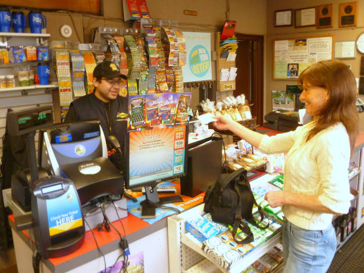 Beth Mulleavey buys a Powerball lottery ticket at Pound Ridge Sunoco on Wednesday afternoon.