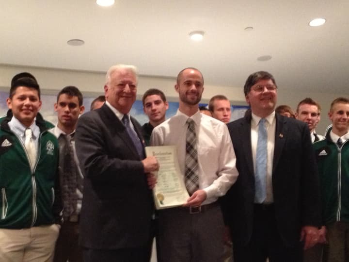 Norwalk Mayor Richard Moccia, left, presents Norwalk High School boys&#x27; soccer coach Chris Laughton with a proclamation honoring the team for winning the Class LL State Championship, as Common Councilman Matt Miklave looks on.