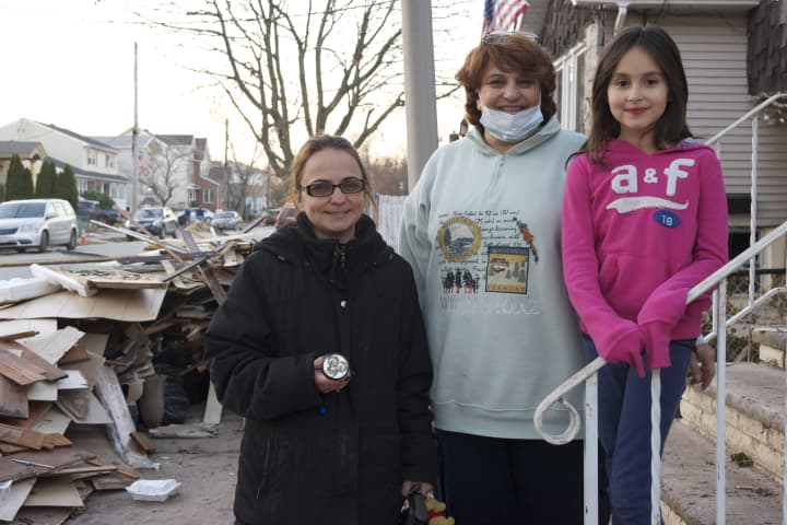Claire Tenney, right, of Stamford, stands with a pair of women from Staten Island, N.Y. whose homes were damaged by Hurricane Sandy. One of them is holding a flashlight that Claire gave them. 