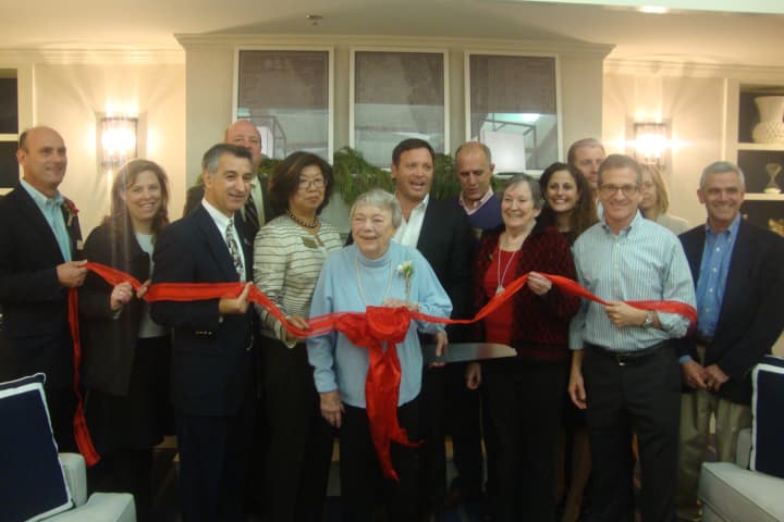The staff and first residents of Maplewood at Darien celebrate the opening with a ribbon cutting alongside Chamber of Commerce members.