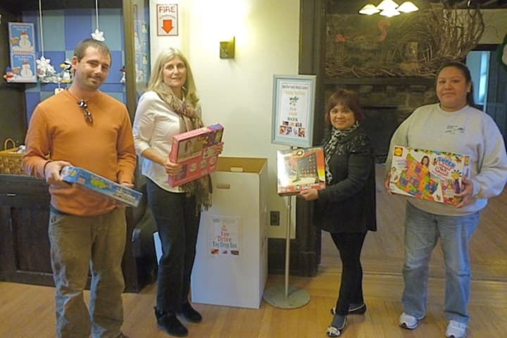 Greenburgh Nature Center employees hold up donated games and toys at their drop-off box on 99 Dromore Road, Scarsdale.