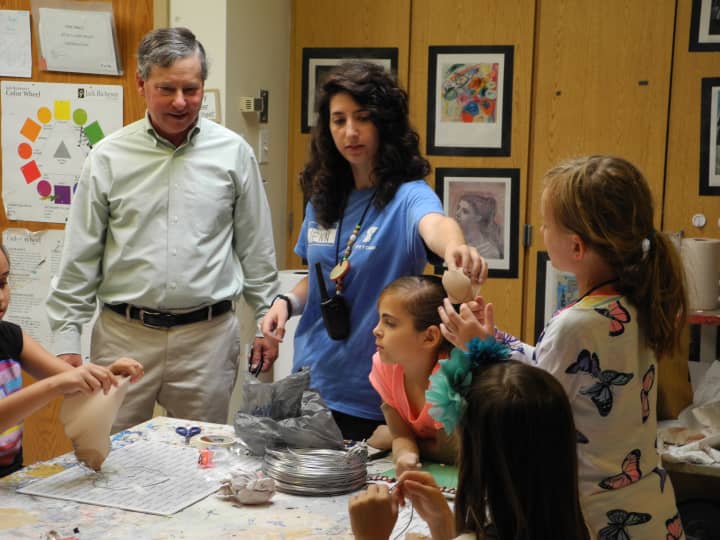 State Assemblyman Steve Otis, a Democrat from Rye, meets with camp counselor Jennifer Cacciola and members of her group during a recent visit to the Rye YMCAs summer camp at Osborn Elementary School.
