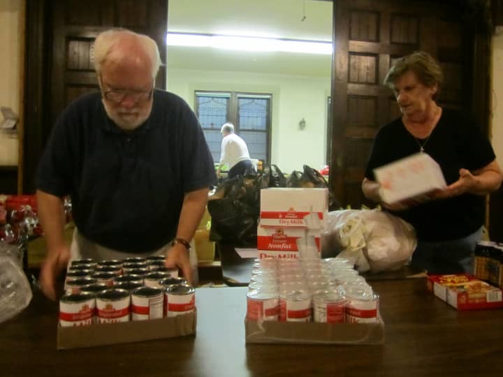 Volunteers Richard Devir Margaret Young prepare food items in September for the Ossining Food Pantry. The pantry is one of several in Ossining and Briarcliff Manor receiving goods through fundraisers this holiday season.