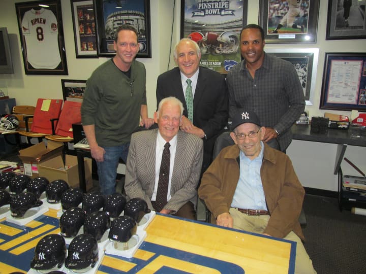 Baseball greats David Cone (left), Barry Larkin (right), Don Larsen (front left) and Yogi Berra (front right) stand with Steiner Sports CEO Brandon Steiner (center) at company headquarters in New Rochelle Wednesday.