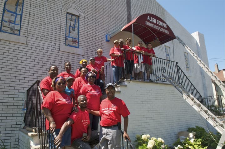 Volunteers who helped re-paint the Allen Temple AME Church pose for a photo in front of the church.