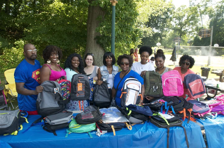 Volunteers gather Saturday for a Family Day and to hand out backpacks. 