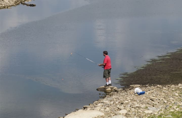 A man fishes in the Amawalk Reservoir Sunday afternoon.