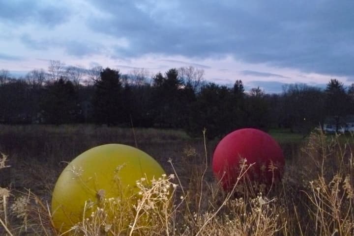 These two spheres on the Keeler Ridge Meadow site off Route 33 in Wilton are part of &quot;All One Color,&quot; an exhibit by artist Christopher Curnan. 