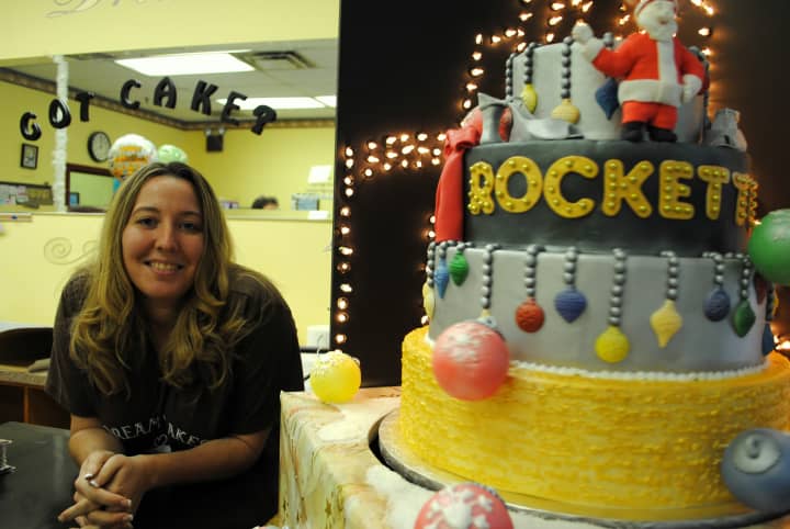 Lynn Ayala, owner of Dream Cakes Bakery, stands with the Radio City Rockettes Christmas cake, from 2011. 