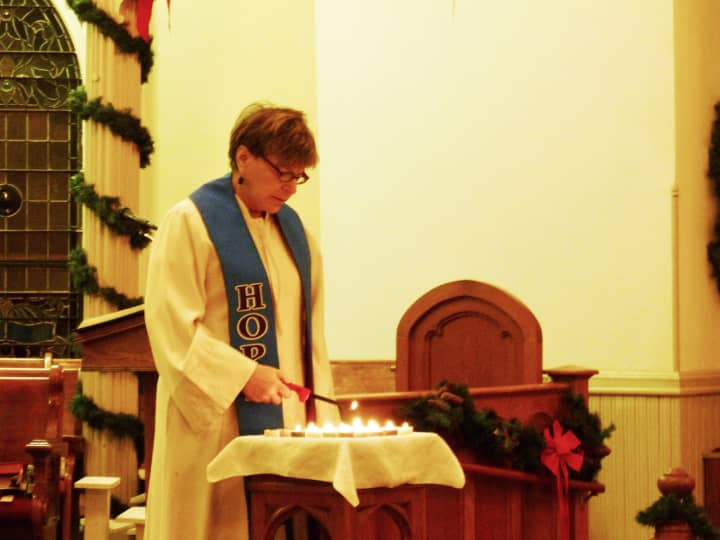 The Rev. Dale Ellen Krazmien of the East Avenue United Methodist Church in Norwalk lights candles Friday night in honor of the victims of the Sandy Hook Elementary School shooting in Newtown.