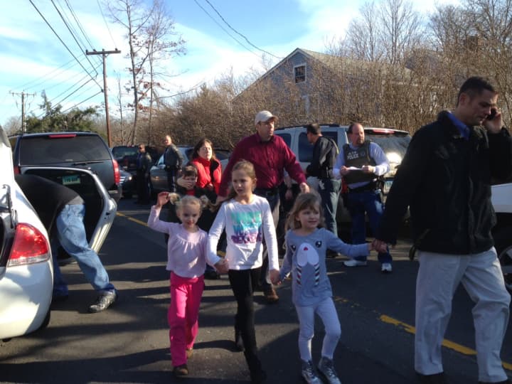 Parents pick up their children from Sandy Hook Elementary School after a gunman shot and killed 26 children and adults there.
