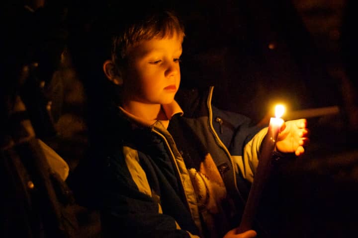 A small boy holds a candle at a vigil on the Village Green in Rye on Sunday night for Friday&#x27;s shooting at Sandy Hook Elementary School in Newtown, Conn.