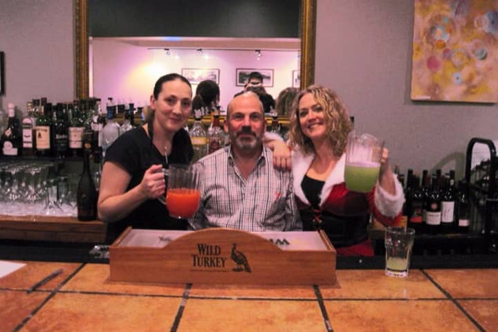 Bartenders Laura Hinkley, left,  Shay Kilby, right, joined Division Street Grill owner Arne Paglia at the bar before SantaCon crawlers arrived.