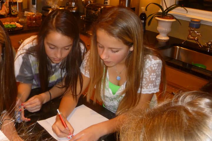 Greenwich middle school students Julia Hryckwian, left, 11, and Molly Spaeth, 12, write a letter of support to Sandy Hook Elementary School in Newtown.