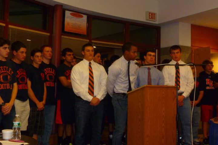 Horace Greeley High School football captain Teddy Graves (at podium) was joined by teammates in support of coach Bill Tribou at a Board of Education meeting May 1.