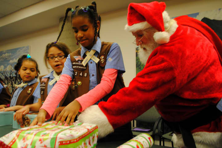 Santa helps a Girl Scout wrap a present, at Hudson Valley Hospital Center&#x27;s &quot;Santa&#x27;s Helpers&quot; event.