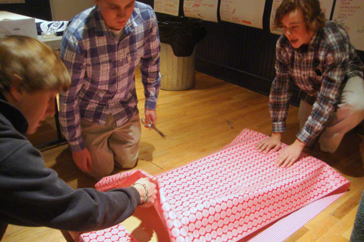 Darien teens team up to wrap a large box at the Depot&#x27;s annual Wrap Up event, which is running through Sunday.