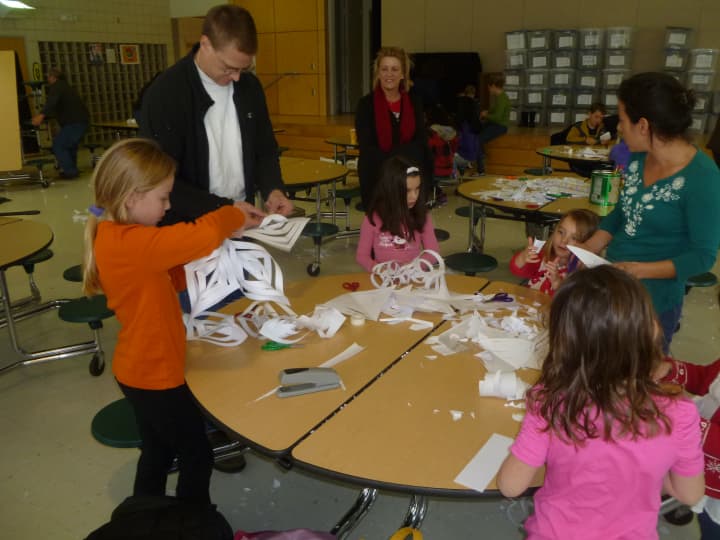 Fairfield families cut snowflakes that will be donated to Sandy Hook School pupils when they start classes at Chalk Hill School in Monroe in January.