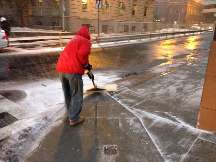A man shovels snow off Main Street in White Plains in front of Walmart on Wednesday. 