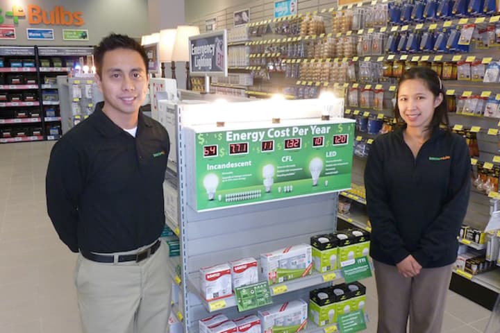 Eros Corpus, left, and his wife, Jennifer, in front of the selection of efficient lightbulbs at their new Greenburgh business, called Batteries Plus Bulbs.