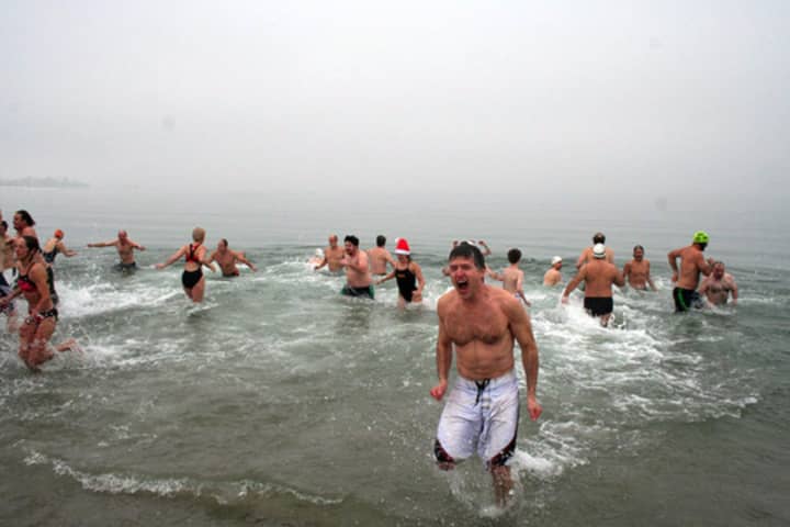 Participants in a past year&#x27;s Team Mossman Polar Plunge at Westport&#x27;s Compo Beach brave the icy waters of Long Island Sound for charity. 