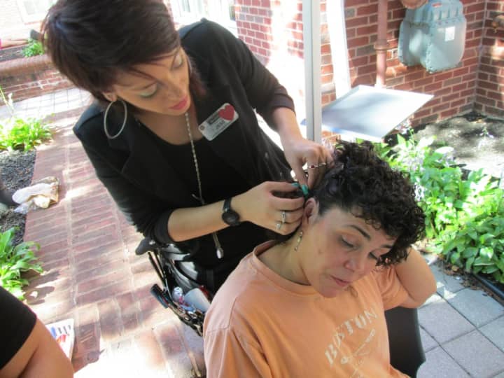 A Paul Mitchell student styles hair at Taste of Danbury in September. The beauty school will have a fundraiser to benefit those affected by the Newtown school shooting.