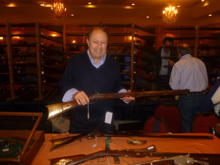 John Fucci holds a 19th-century Kentucky rifle he was selling at the East Coast Fine Arms show Saturday in Stamford.
