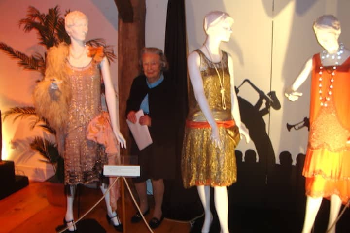 Babs White with some of the dresses currently on display at &quot;Stepping Out in the Jazz Age&quot; at the Darien Historical Society.
