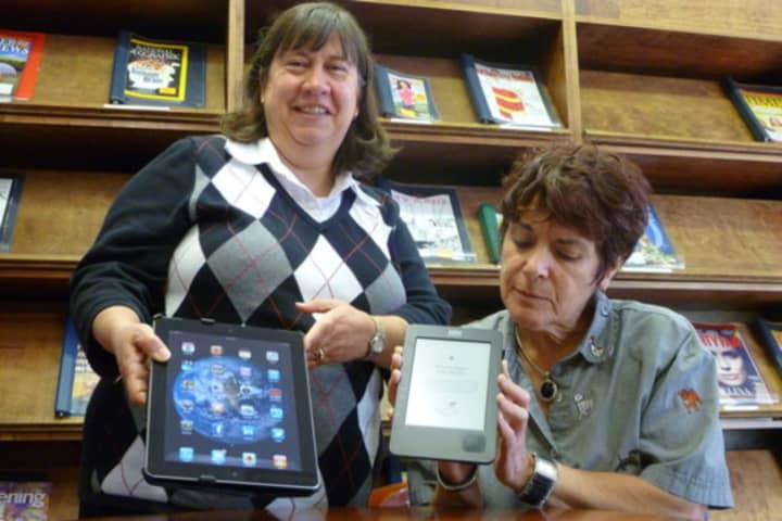 Lewisboro Library Director Cindy Rubino, left, and Children&#x27;s Librarian Cathy Lim with some digital devices to which patrons can now download books.