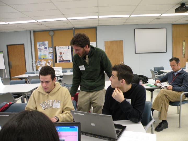 Paul Monaghan from Dobbs Ferry High School, left, and Nicholas Jacobino, Walter Panas High School, met with teacher Travis Hayes at a symposium in Yorktown Heights.