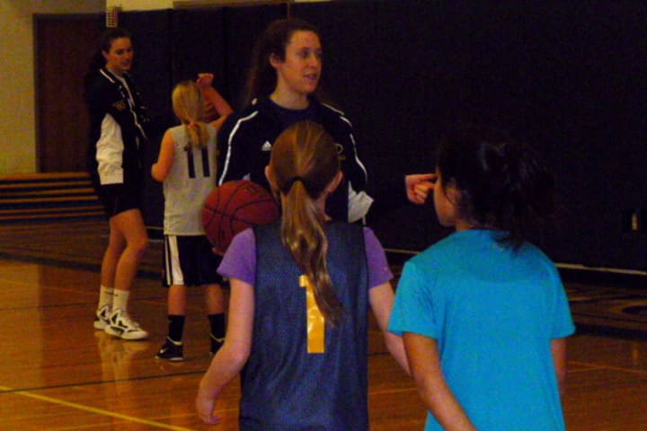 Weston High School senior Zoe Zegers talks to young girls at a basketball camp Monday.