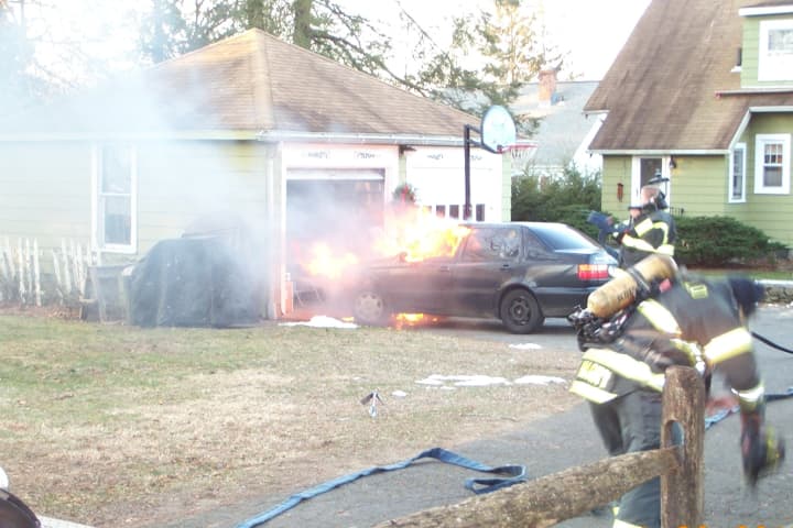 Fairfield firefighters work to put out a car fire on Church Hill Road Tuesday.