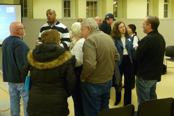 Mike Chambers, Greenwich director of inland wetlands and watercourses, left, and Amy Siebert, Greenwich Commissioner of Public Works, right, speak with residents at Wednesday&#x27;s informational meeting on the Byram River flooding study.